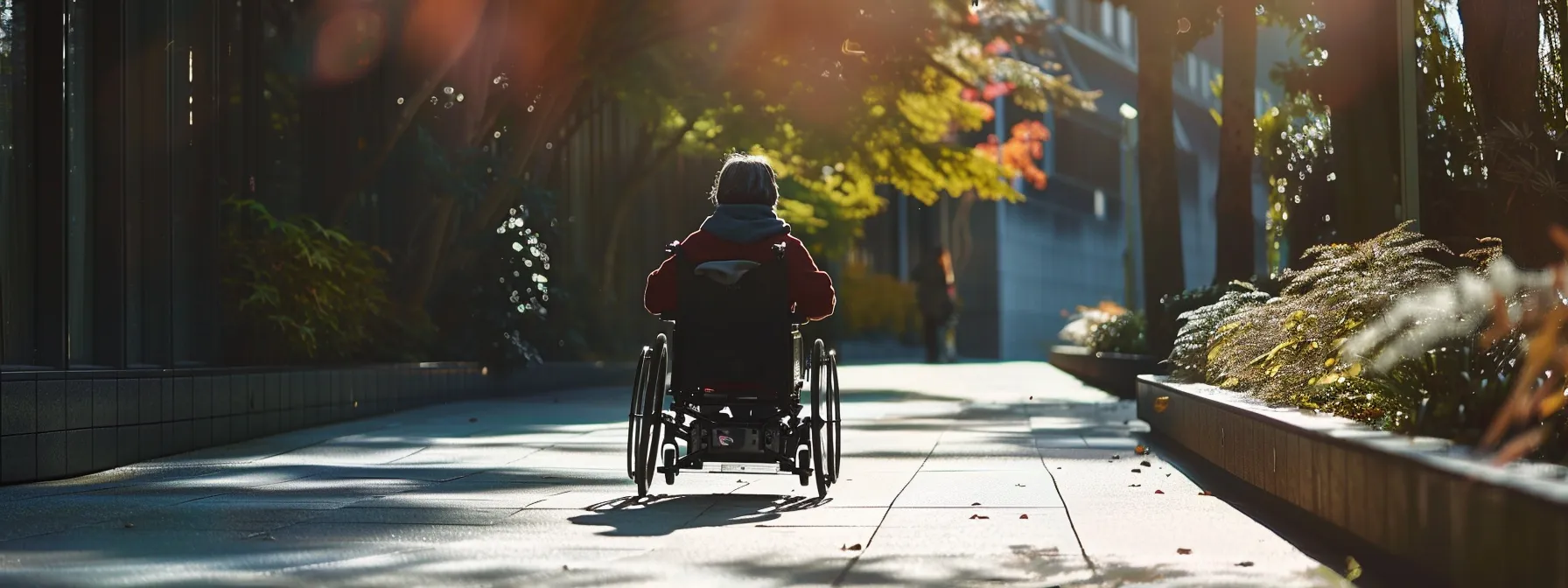 a person in a wheelchair smoothly navigating a wide and smoothly paved pathway.