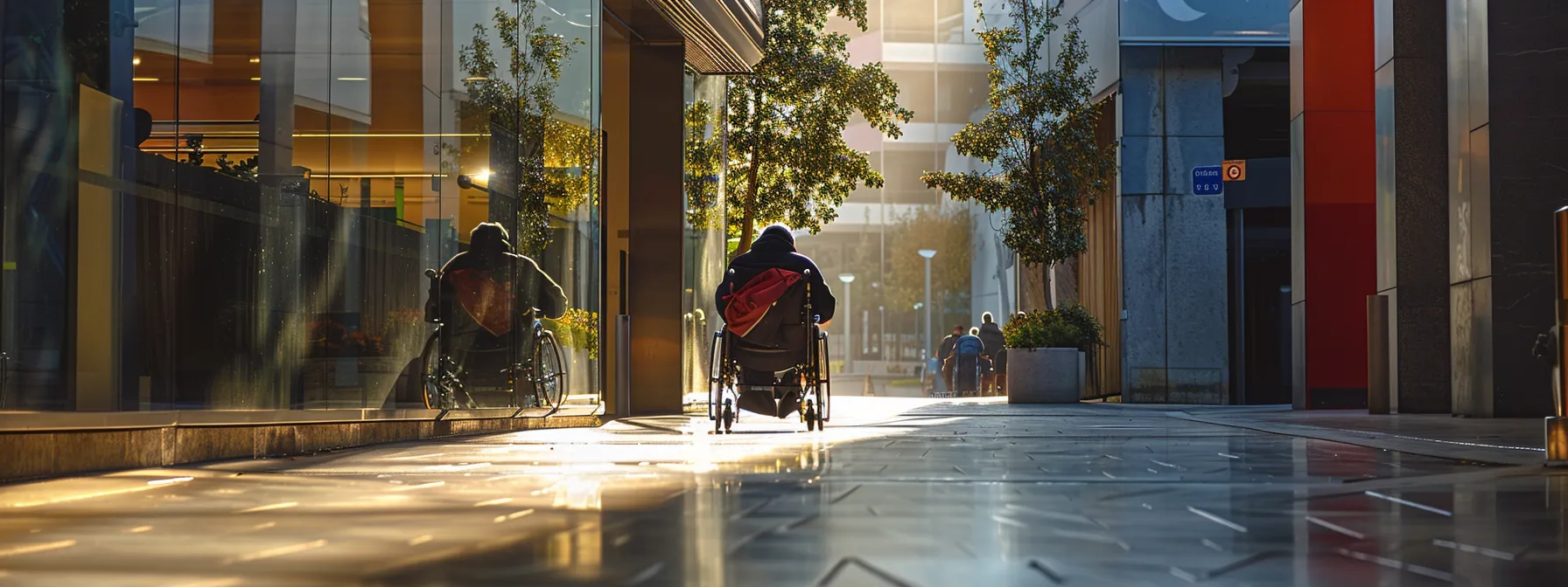 a person in a wheelchair navigating a wheelchair ramp in a public space.