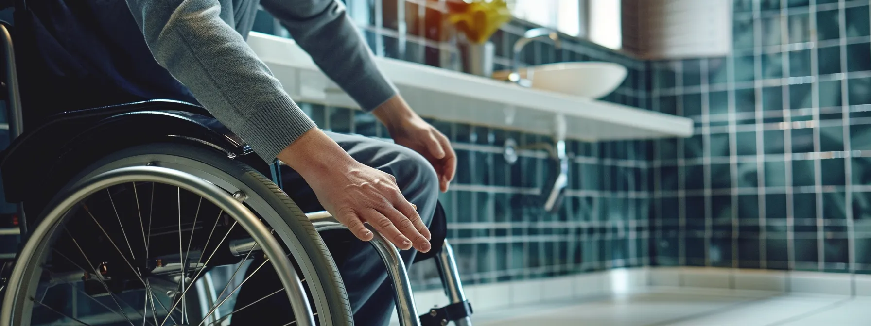 a person in a wheelchair comfortably using a sink with ample knee space underneath.