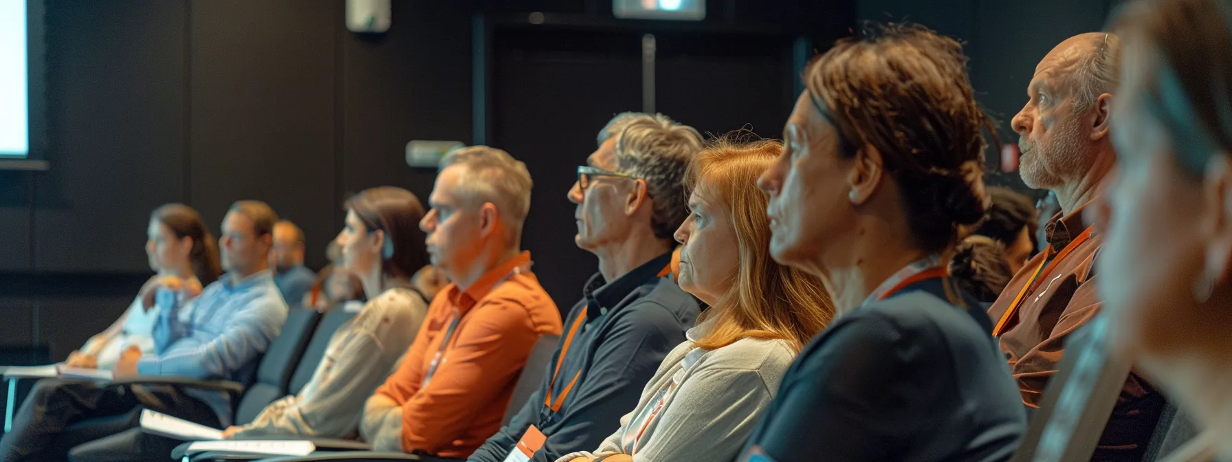 a group of staff members attentively listening to a presentation on knee clearance standards.