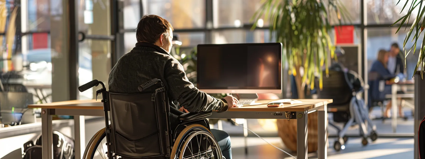 a wheelchair user comfortably maneuvering into a desk space with ample knee clearance and handrails for safety.