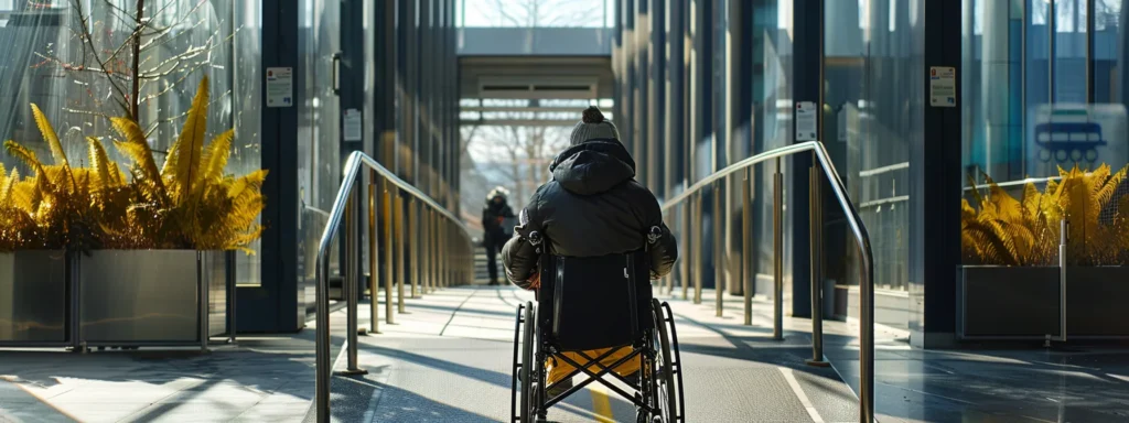 a person in a wheelchair entering a ramp with proper slope and handrails, with a sign indicating ada compliance.