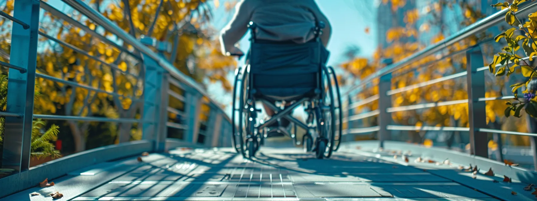 a person in a wheelchair navigating a ramp with handrails.