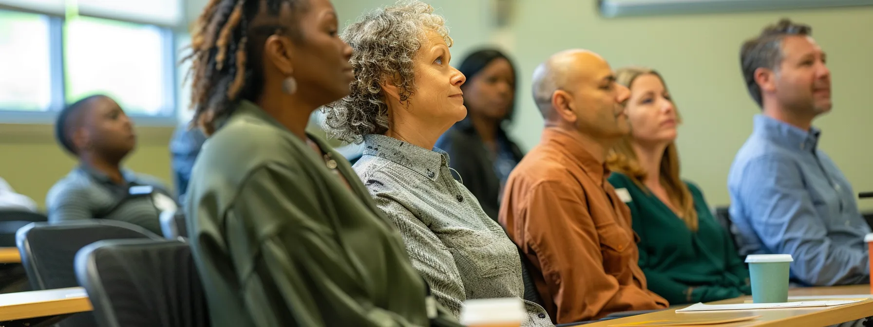 a diverse group of professionals sitting in a classroom setting, engaged in an ada training session.