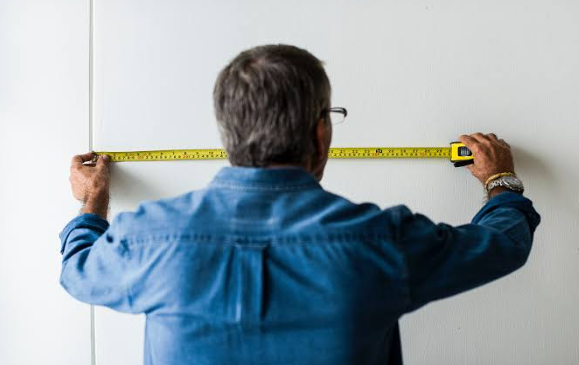 man measuring the board